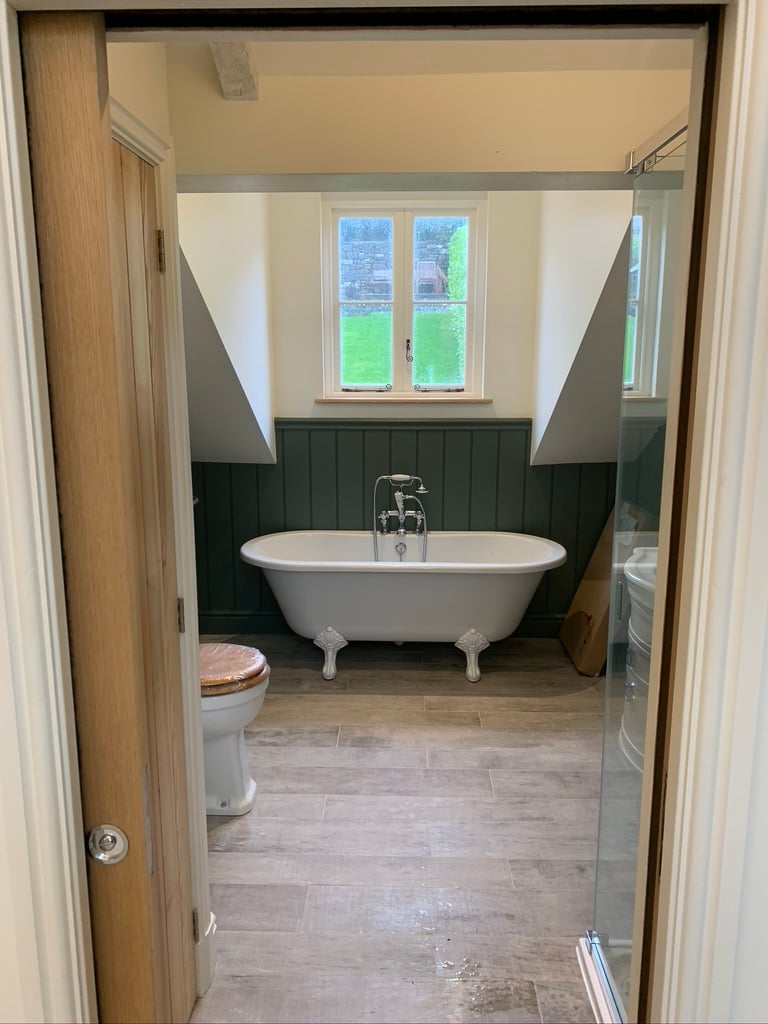 Bathroom with green panelling and freestanding bath